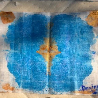 En stilla kompass — flowing blue pigment with a quiet g